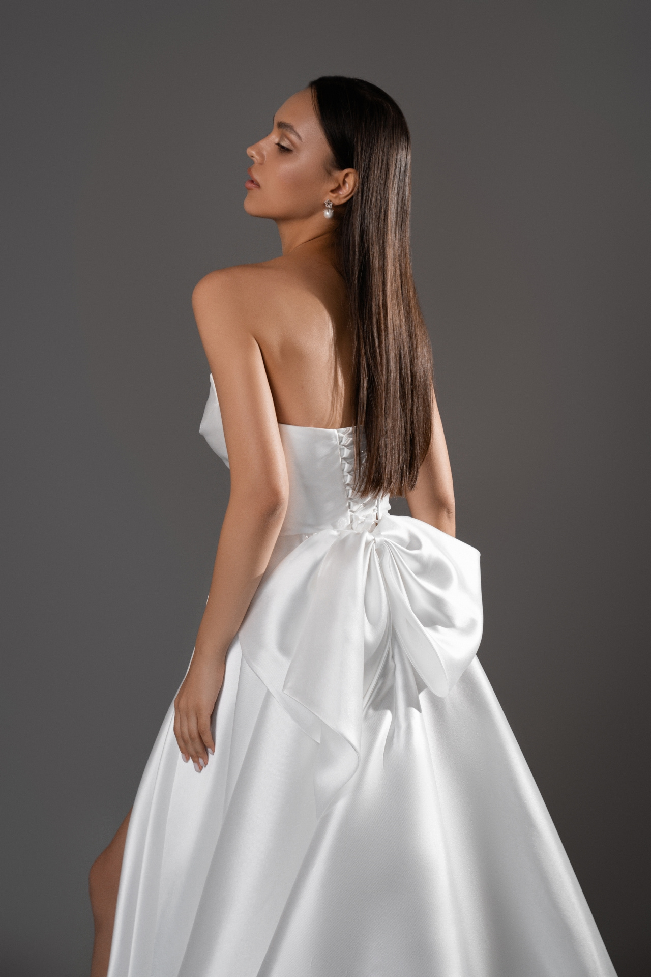 Лаконичное свадебное платье с разрезом и бантом фото