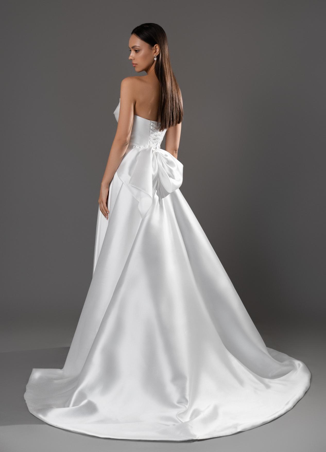 Лаконичное свадебное платье с разрезом и бантом фото