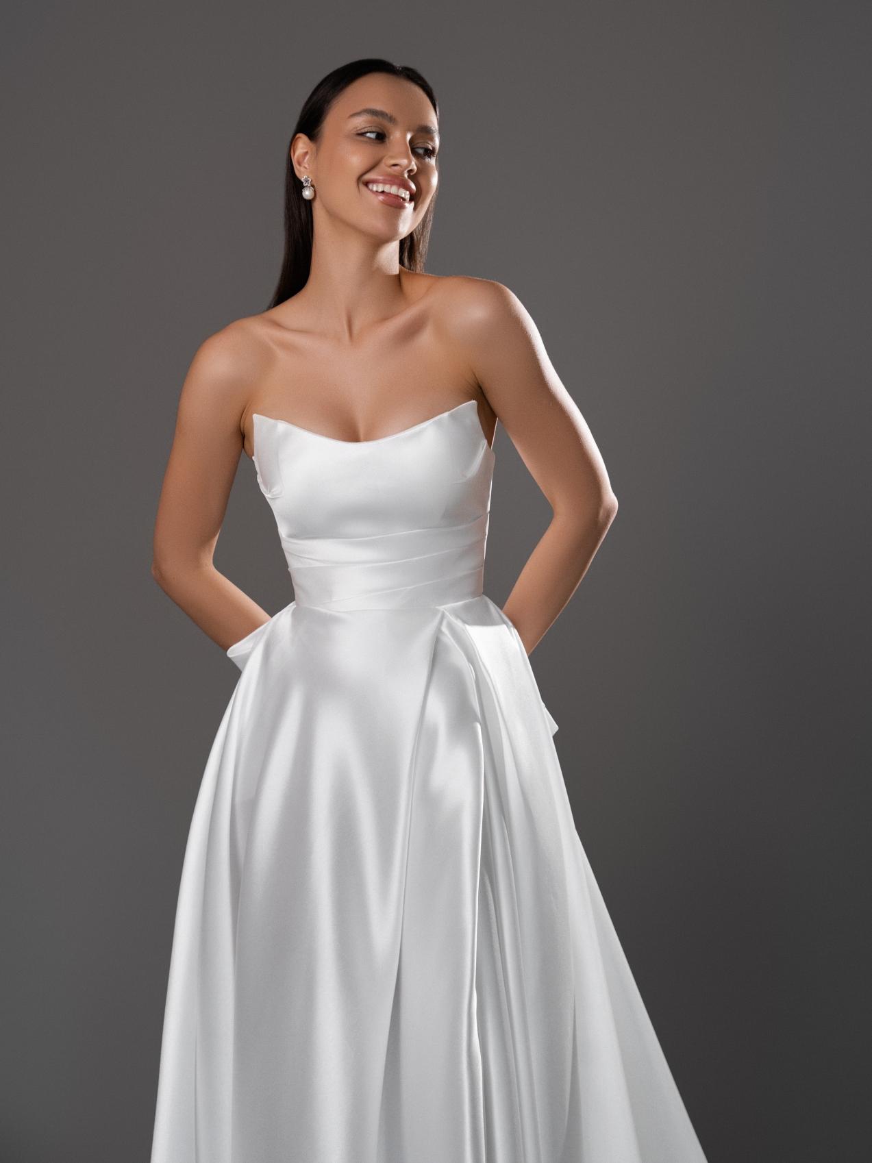 Лаконичное свадебное платье с разрезом и бантом фото