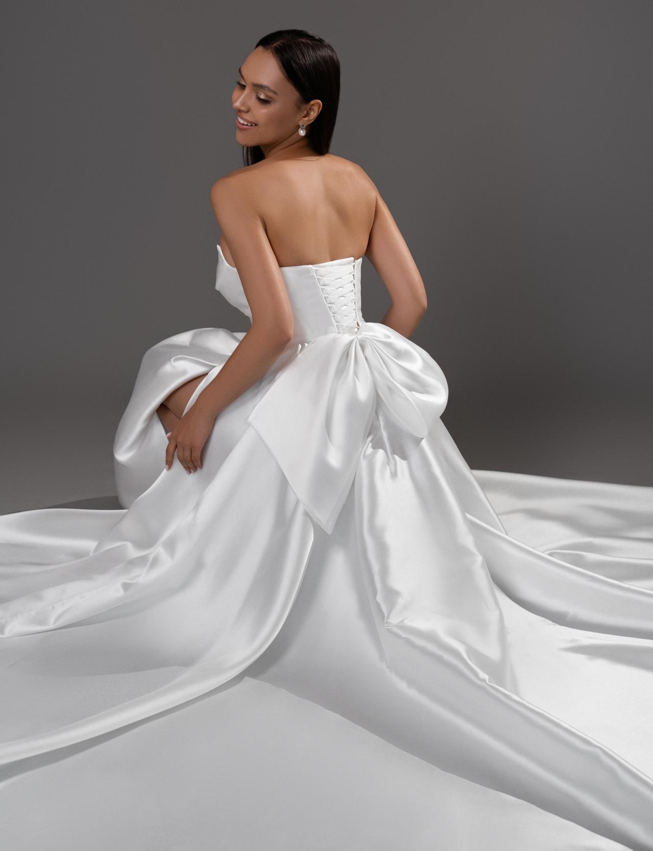 Лаконичное свадебное платье с разрезом и бантом фото